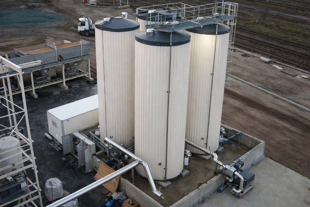 Dört dikey bitüm tankı — üst yürüyüş platformu ve hat bağlantıları